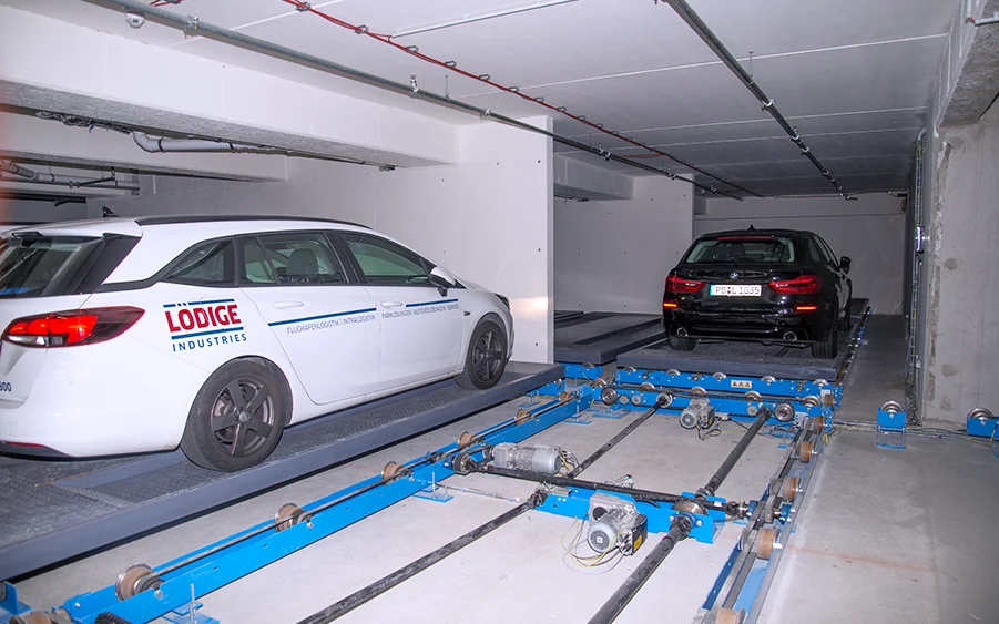 Een witte auto staat geparkeerd in een automatisch parkeersysteem.